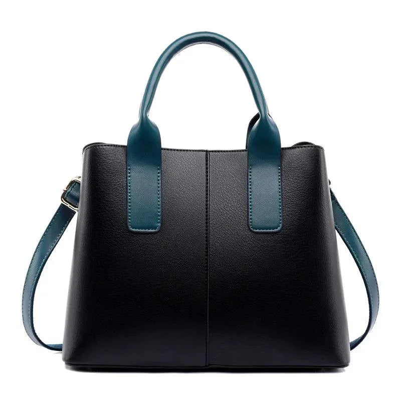 Black leather handbag with teal handles and shoulder strap on white background
