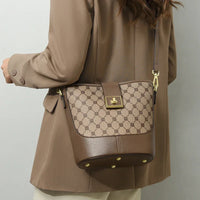 Woman wearing brown geometric bucket bag with gold hardware and crossbody strap