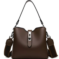 Brown leather handbag with metal clasp and adjustable strap on white background