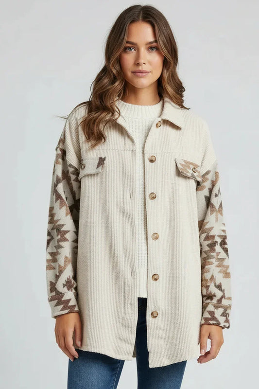 Woman wearing a beige shirt with camouflage sleeves and blue jeans on a white background